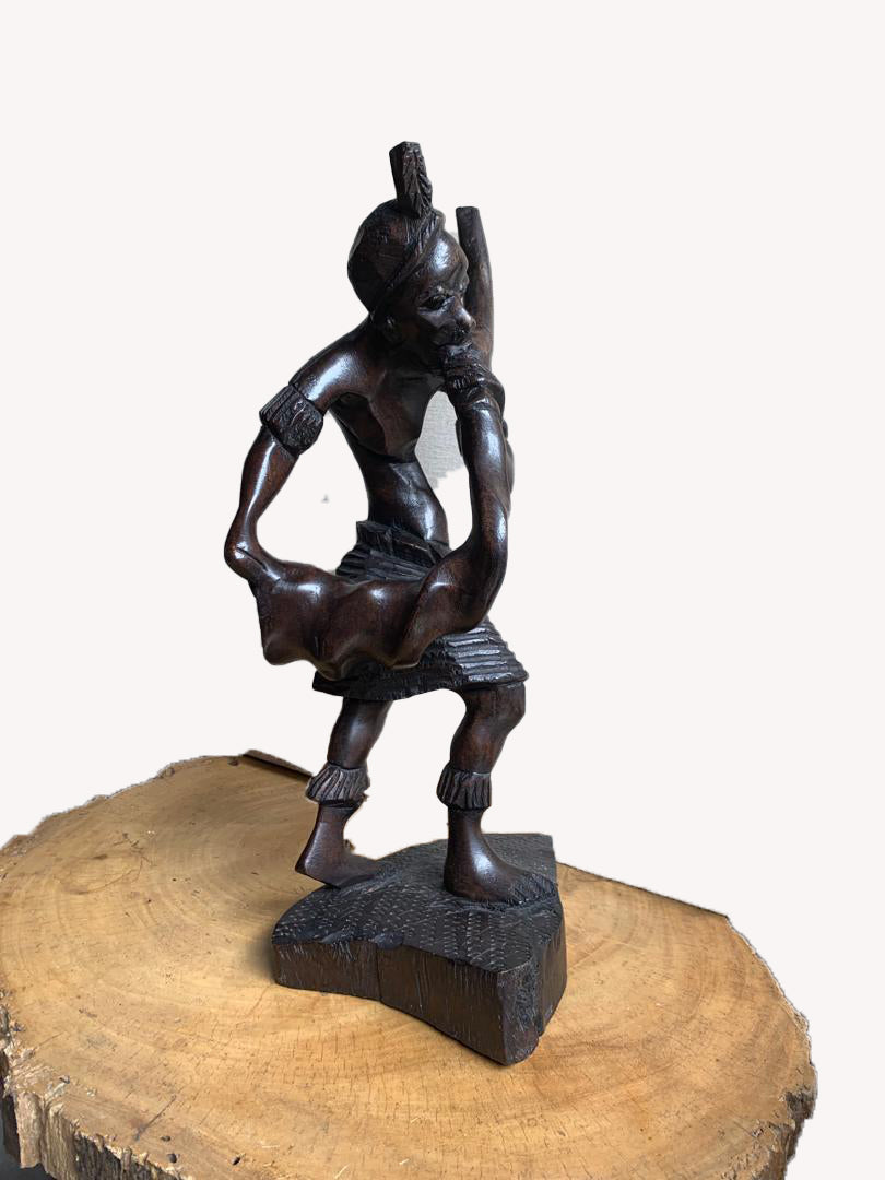 An abstract carved Hausa flute player