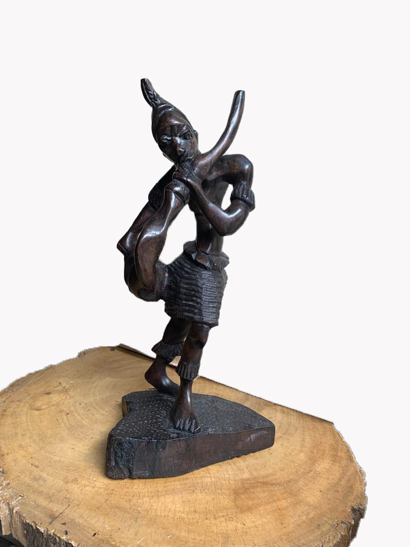 An abstract carved Hausa flute player